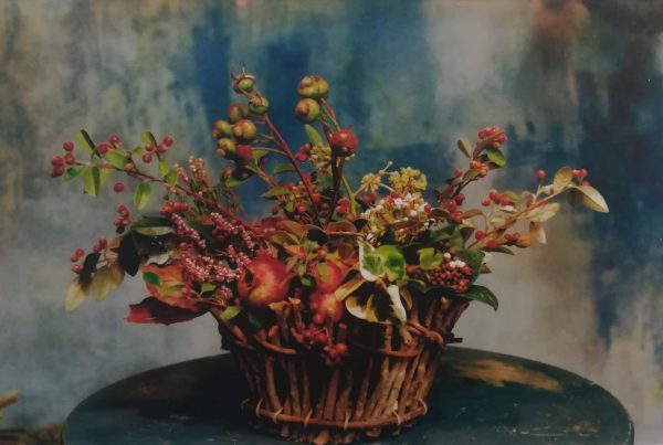 composizione artistica di fiori e ramoscelli all'interno di un cestino di vimini